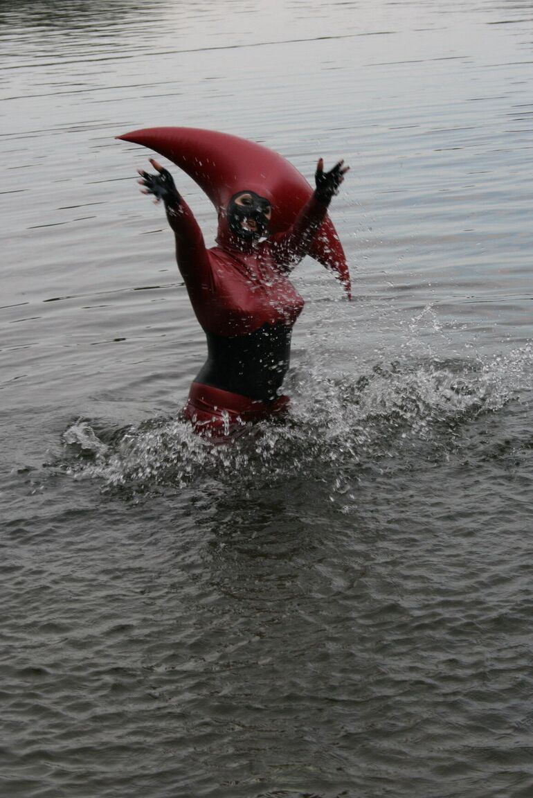 Le modèle fétichiste 16P Avengelique patauge dans un plan d'eau dans un costume en caoutchouc