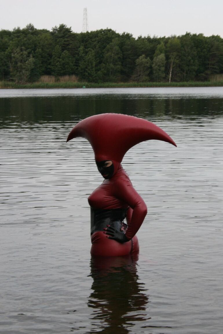 Le modèle fétichiste 16P Avengelique patauge dans un plan d'eau dans un costume en caoutchouc