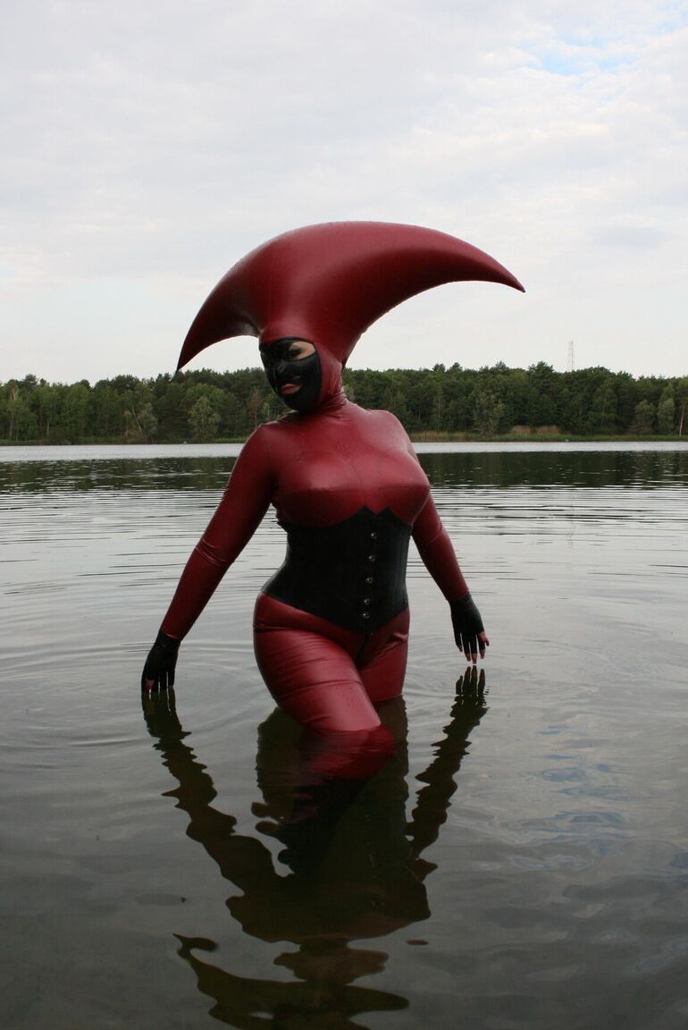 Le modèle fétichiste 16P Avengelique patauge dans un plan d'eau dans un costume en caoutchouc