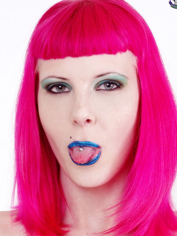15P Goth model Szandora sticks out her pierced tongue while wearing a laced corset