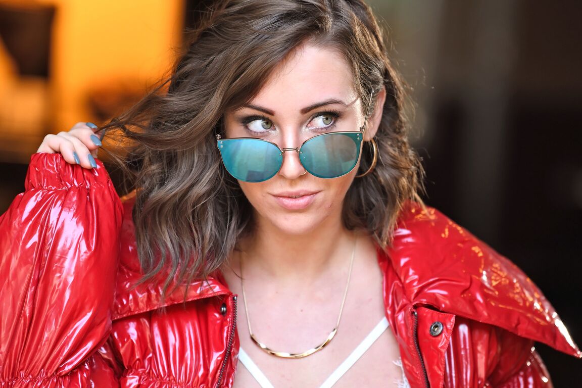 16P La fille sexy Kristen Noelle enlève ses lunettes de soleil et son manteau pour poser nue dans des bas sexy.