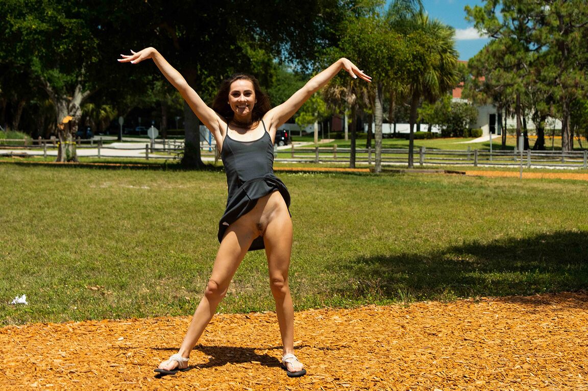 15P Thin girl Mackenzie is all smiles while flashing her tits and ass in a park