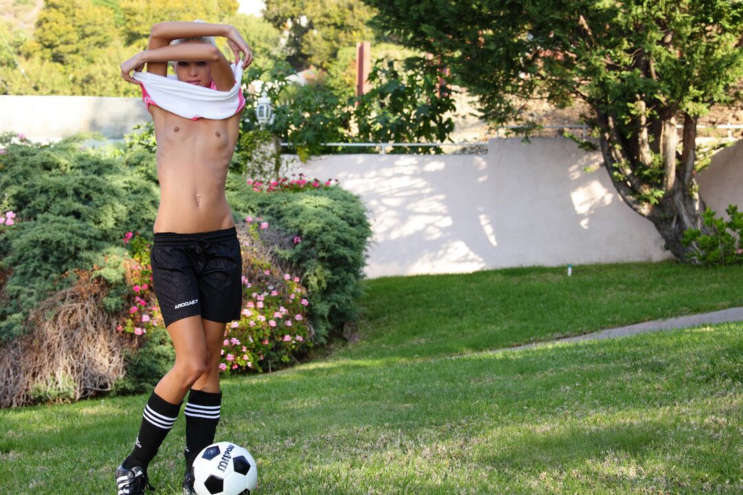 16P Garota loira magra descobre peitos minúsculos enquanto quica uma bola de futebol ao ar livre