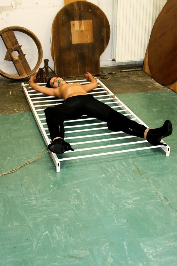 16P Dark haired female with tiny tits is ball gagged and tied to improvised rack