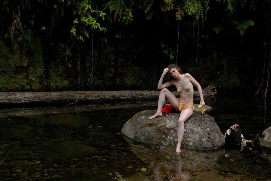 16P Slim girl Liana takes off her bikini while sitting on a boulder in the water