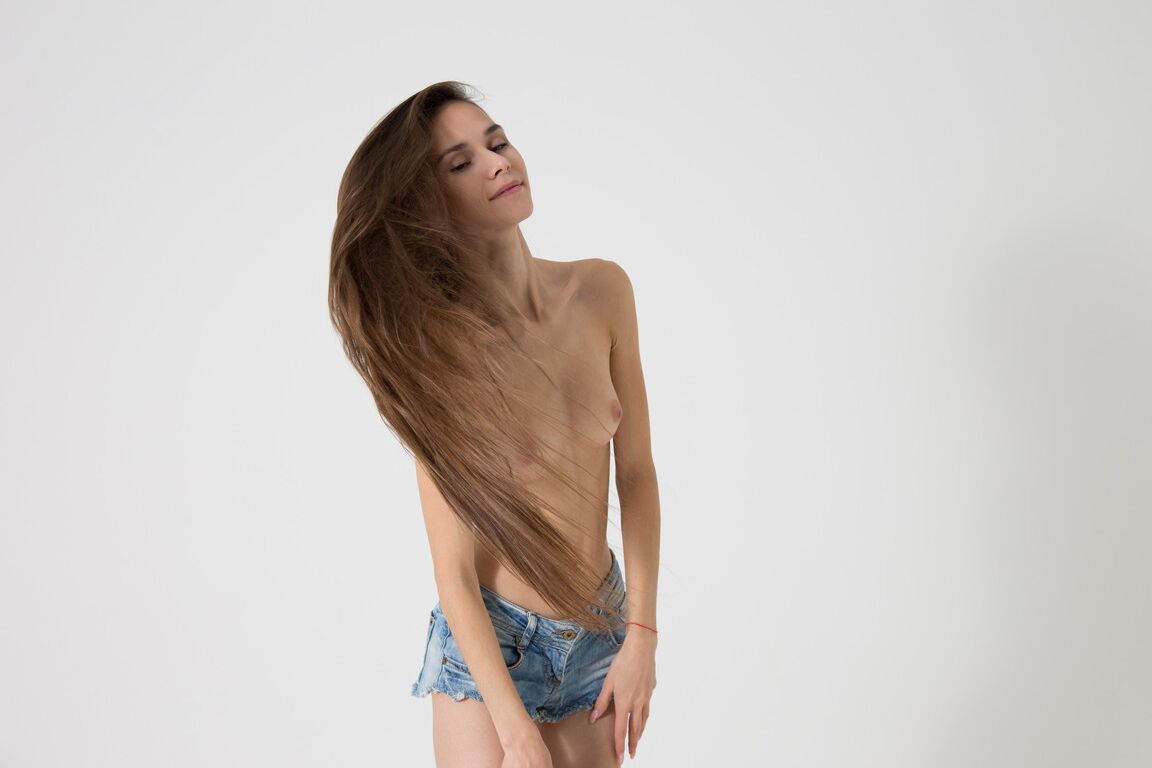 21P A adolescente russa morena Leona Mia exibe seu corpo magro em um strip-tease quente