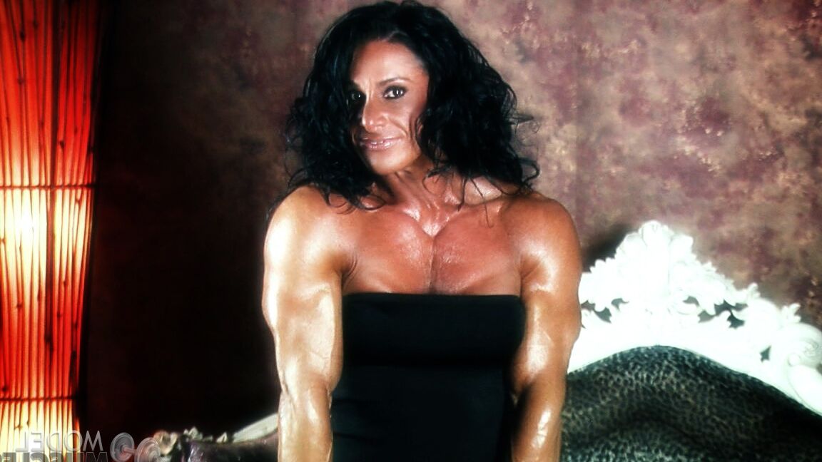 21P Brunette bodybuilder Debbie Bramwell flexing her strong body & her tight ass