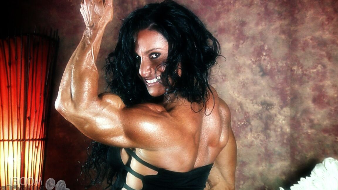 21P Brunette bodybuilder Debbie Bramwell flexing her strong body & her tight ass