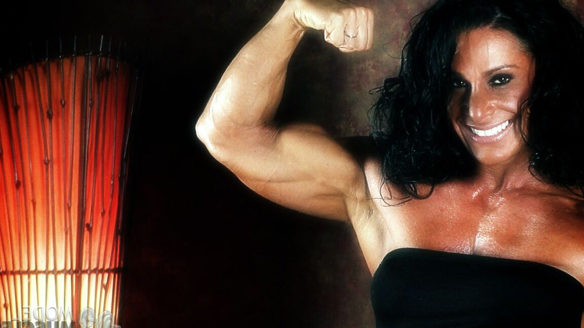 21P Brunette bodybuilder Debbie Bramwell flexing her strong body & her tight ass