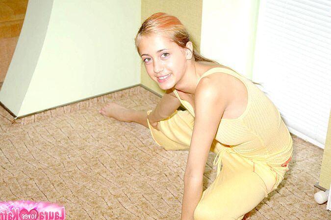10P Flexible young girl stretches out on carpeted flooring while fully clothed
