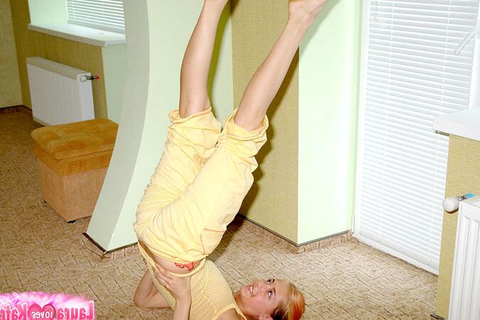10P Flexible young girl stretches out on carpeted flooring while fully clothed