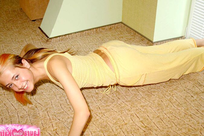 10P Flexible young girl stretches out on carpeted flooring while fully clothed