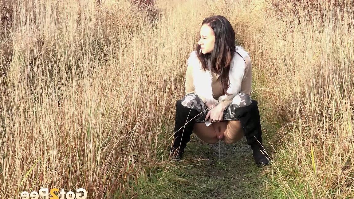 15P Dark haired babe pisses in the long grass outside