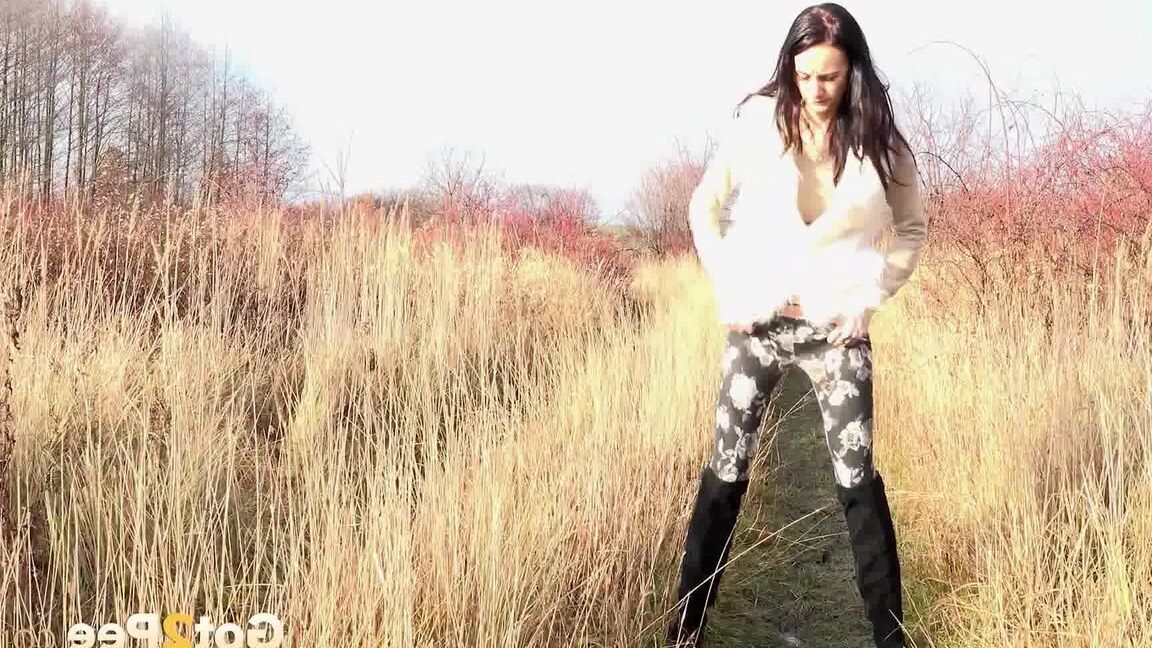 15P Dark haired babe pisses in the long grass outside