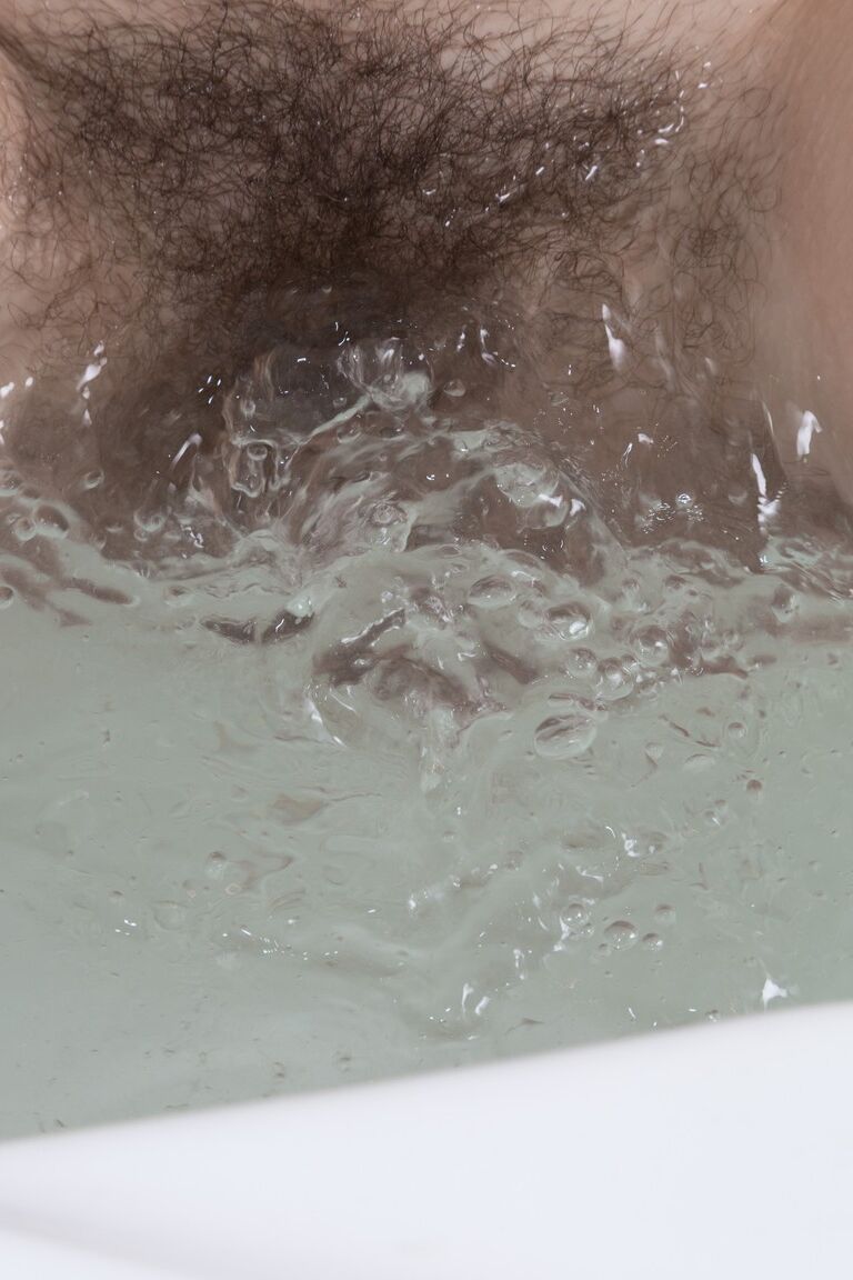 21P Kira Tomson, une jeune amateur maigre, dévoile sa chatte poilue et la frotte dans une baignoire.