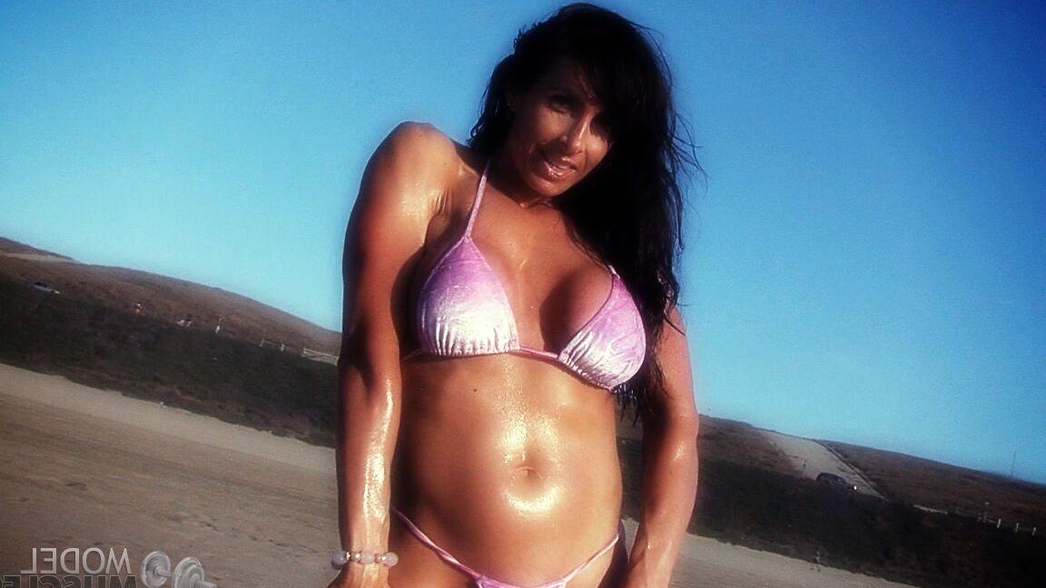 21P Die amerikanische Bodybuilderin Elise Penn stellt ihre glänzenden Bauchmuskeln und ihren Körper im Freien zur Schau