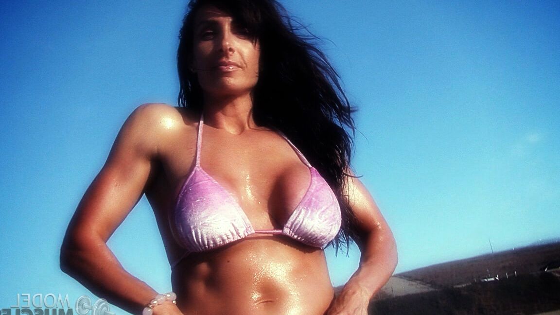 21P Die amerikanische Bodybuilderin Elise Penn stellt ihre glänzenden Bauchmuskeln und ihren Körper im Freien zur Schau