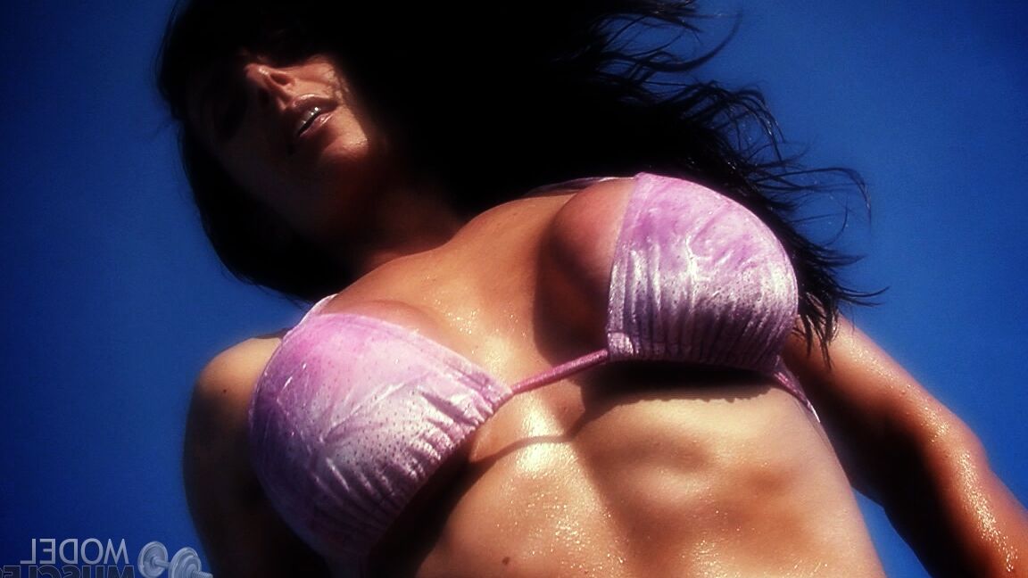 21P Die amerikanische Bodybuilderin Elise Penn stellt ihre glänzenden Bauchmuskeln und ihren Körper im Freien zur Schau