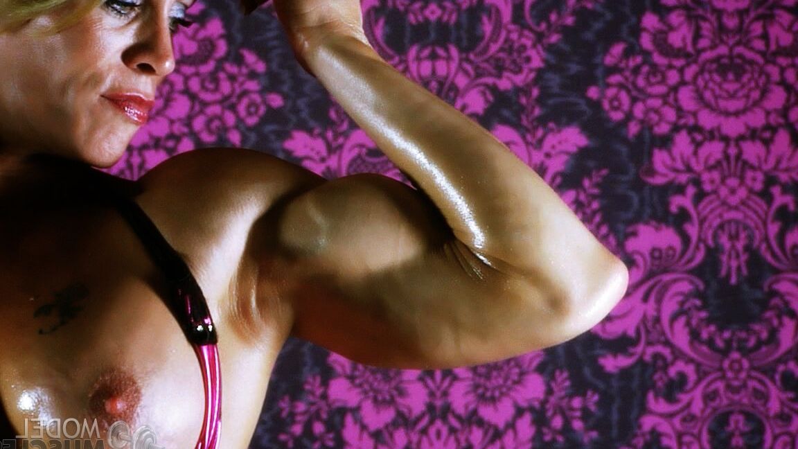 21P A fisiculturista loira Ginger Martin flexionando seus grandes músculos oleados