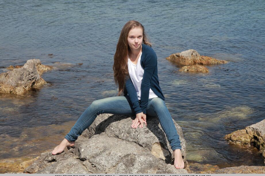 Milena D, une fille maigre de 18P, enlève son jean sur la plage pour montrer sa chatte chauve sous l'eau.