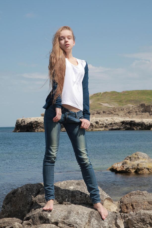 Milena D, une fille maigre de 18P, enlève son jean sur la plage pour montrer sa chatte chauve sous l'eau.