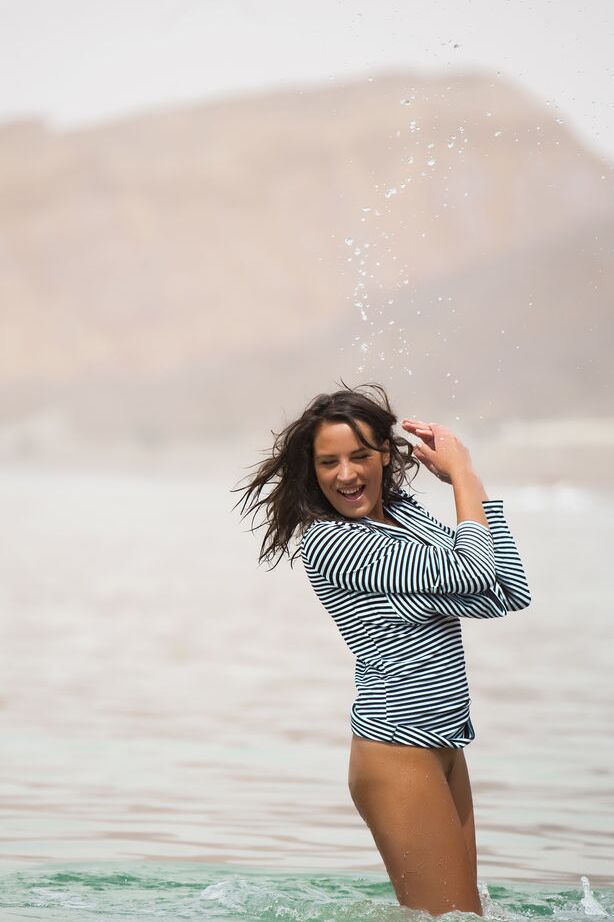 16P Glamour model Saylor stands knee deep in water while exposing her toned body