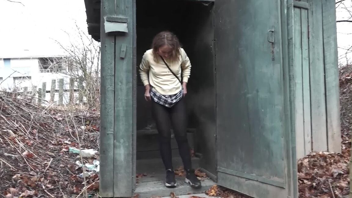 15P Caucasian girl takes a piss in an outhouse while in a forest