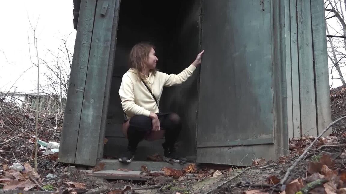 15P Caucasian girl takes a piss in an outhouse while in a forest