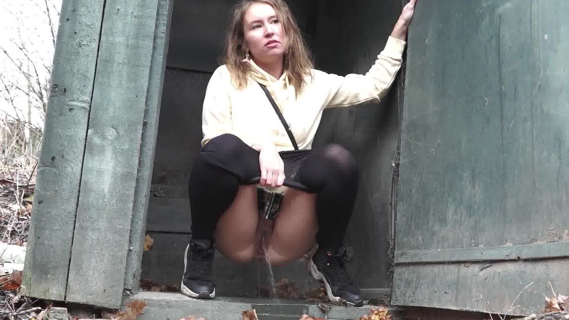 15P Caucasian girl takes a piss in an outhouse while in a forest