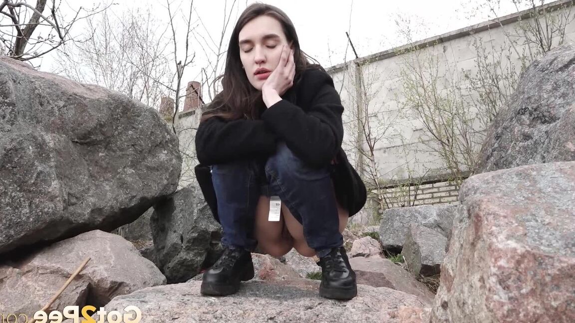 15P Brunette chick Lara Fox pulls down her jeans to take a piss upon boulders