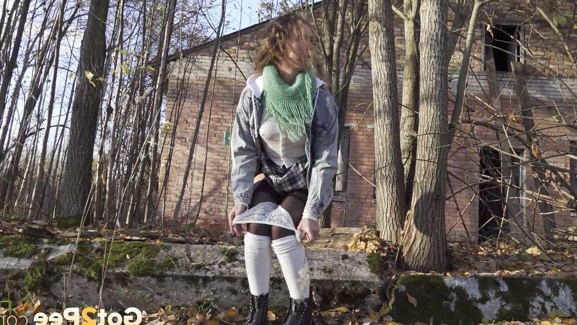 15P Rita, une fille prise à court terme, prend une pisse indispensable près de quelques arbres sans feuilles