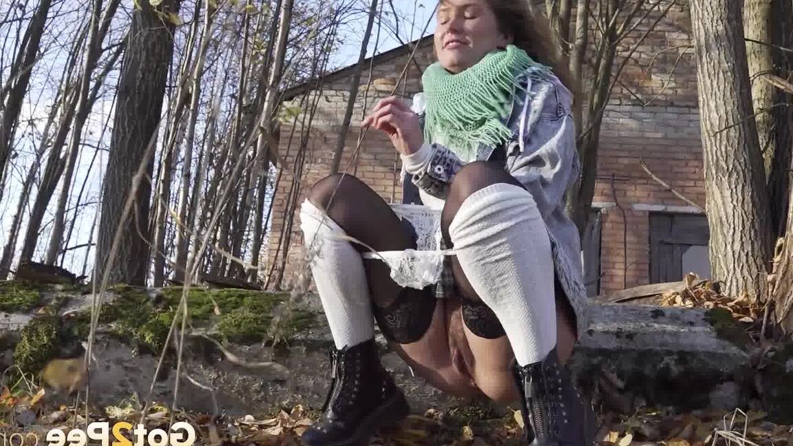 15P Rita, une fille prise à court terme, prend une pisse indispensable près de quelques arbres sans feuilles