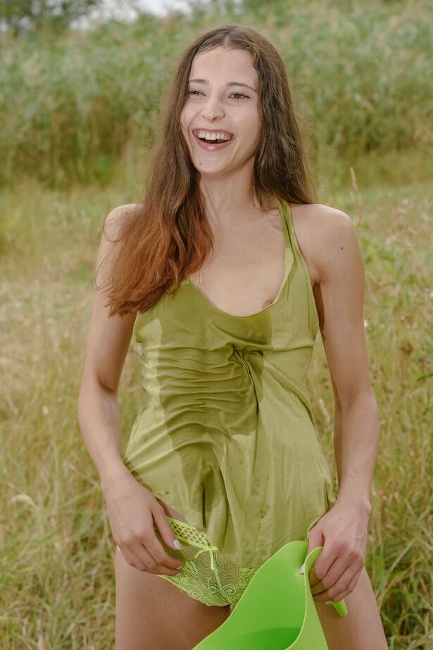 18P Young brunette Mattie wets herself down before getting naked in a field