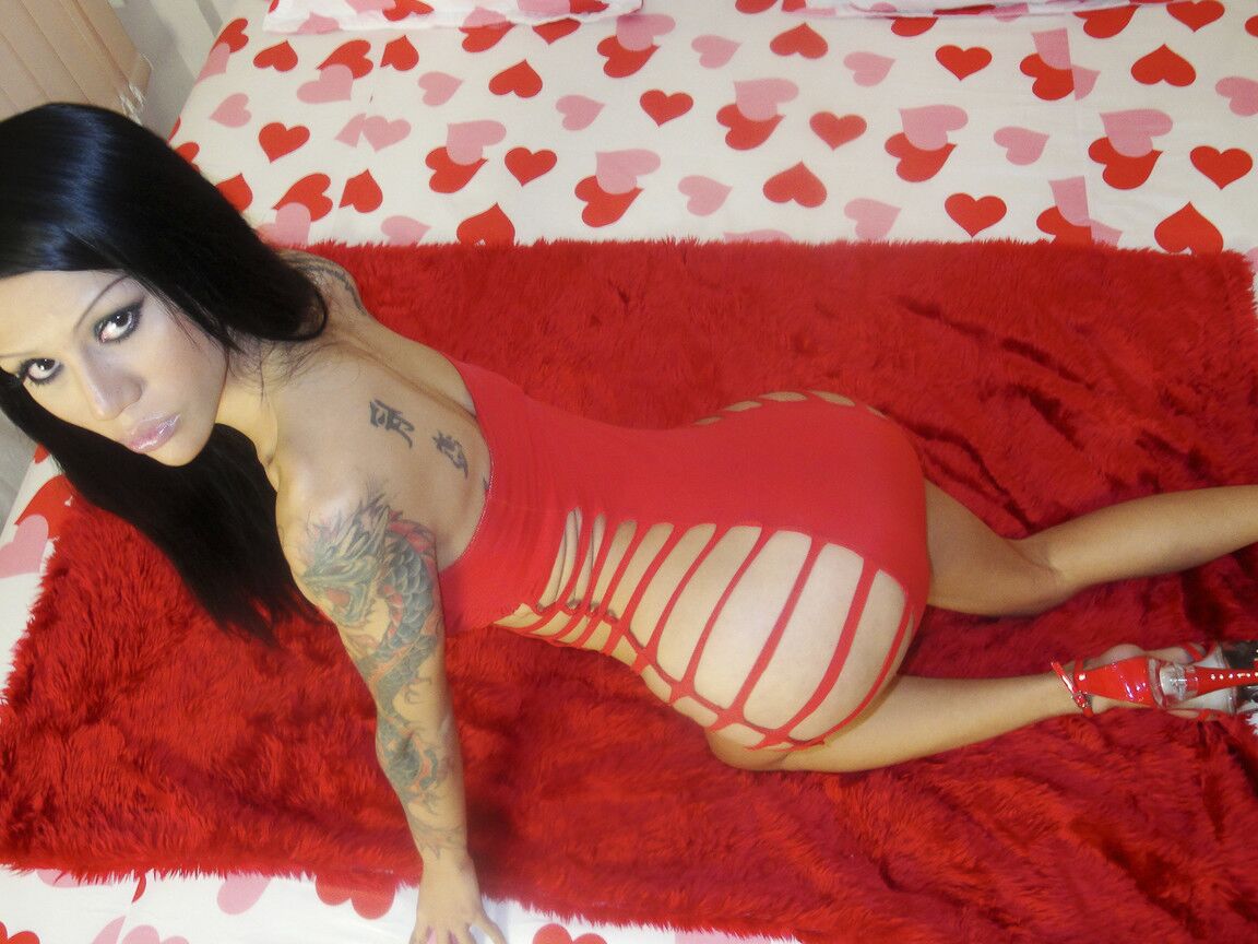 17P Emmy, une transsexuelle chaude et fumante, enlève sa robe rouge sexy et joue avec sa bite