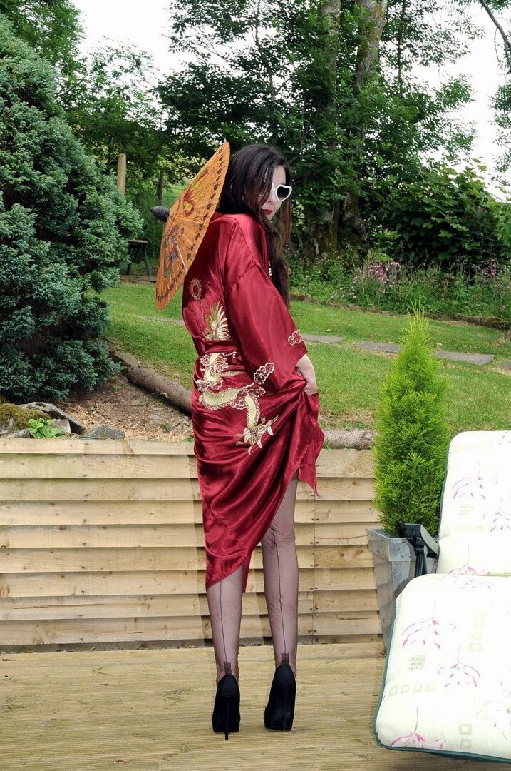 15P Dark haired woman lets a boob loose while modeling sheer nylons on patio