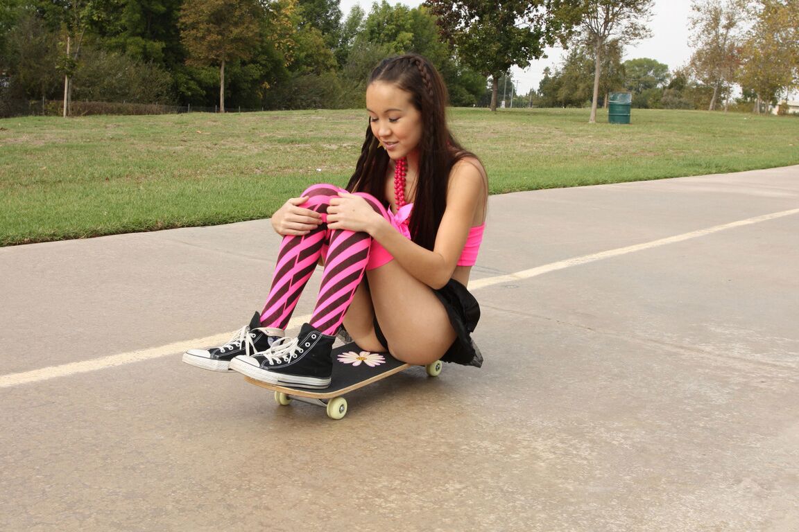 18P Tiny Asian teen Amai Liu posing in short skirt on the skateboard