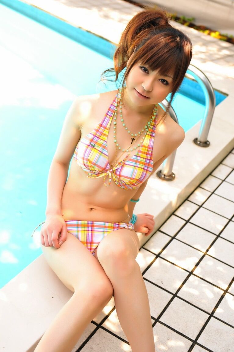 12P Tiny Asian girl wears her hair in a ponytail while modeling a bikini by a pool