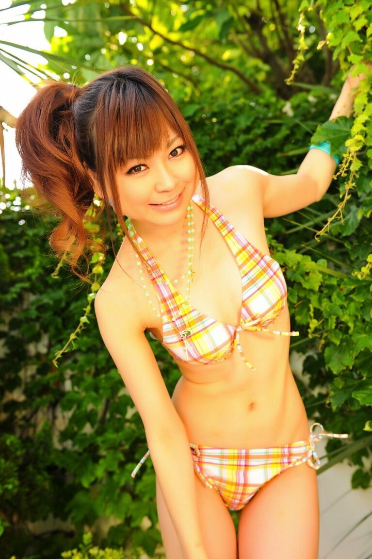 12P Tiny Asian girl wears her hair in a ponytail while modeling a bikini by a pool