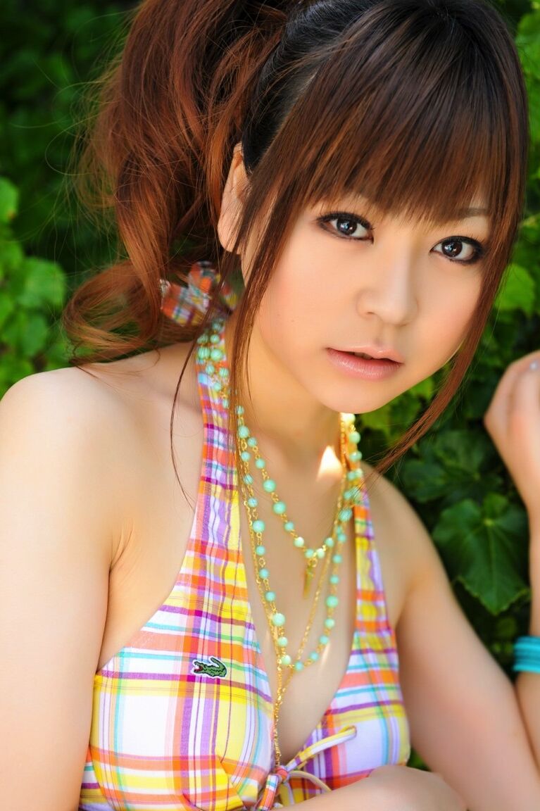12P Tiny Asian girl wears her hair in a ponytail while modeling a bikini by a pool