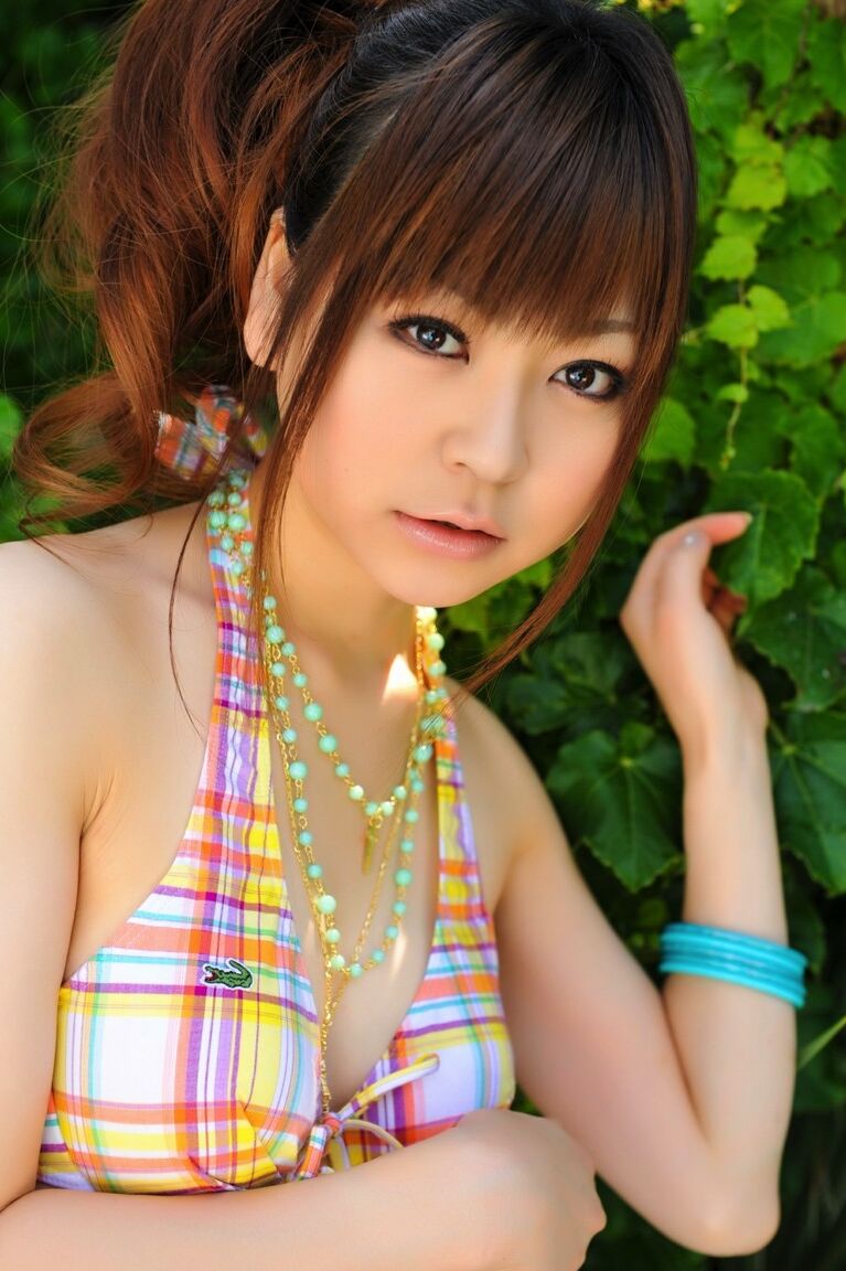12P Tiny Asian girl wears her hair in a ponytail while modeling a bikini by a pool