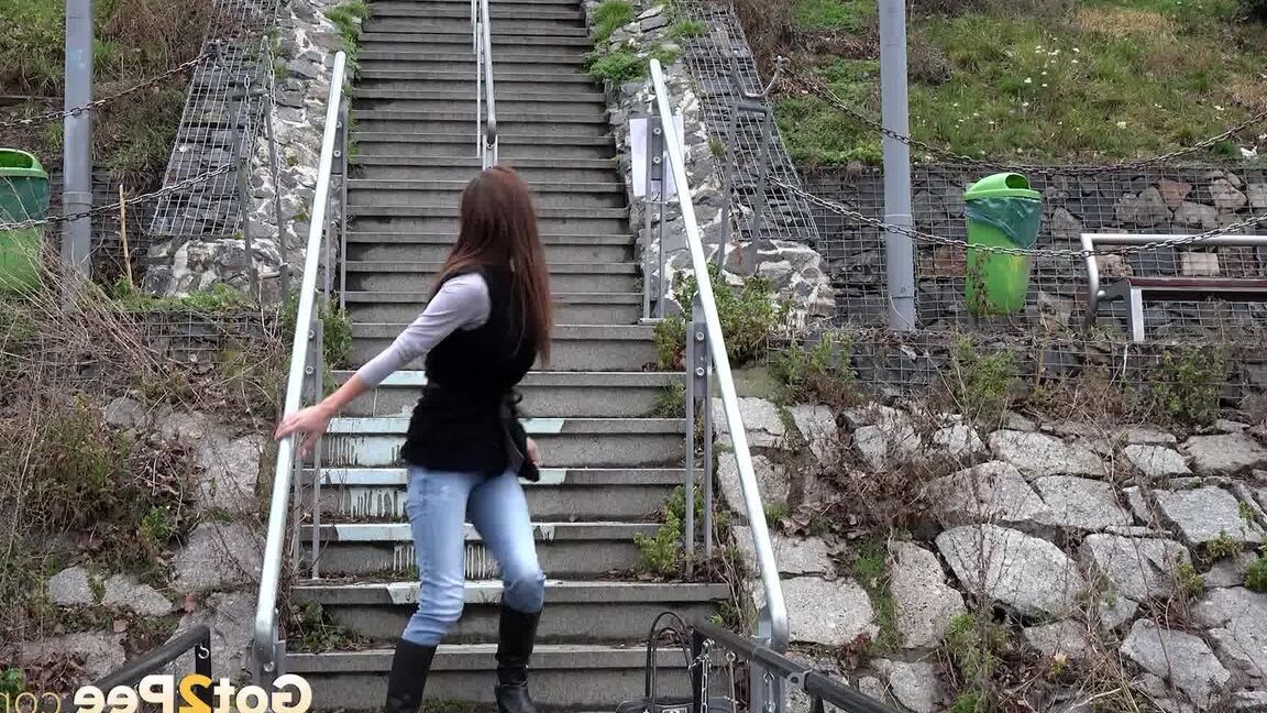 15P Sexy brunette babe pisses in public on some steps