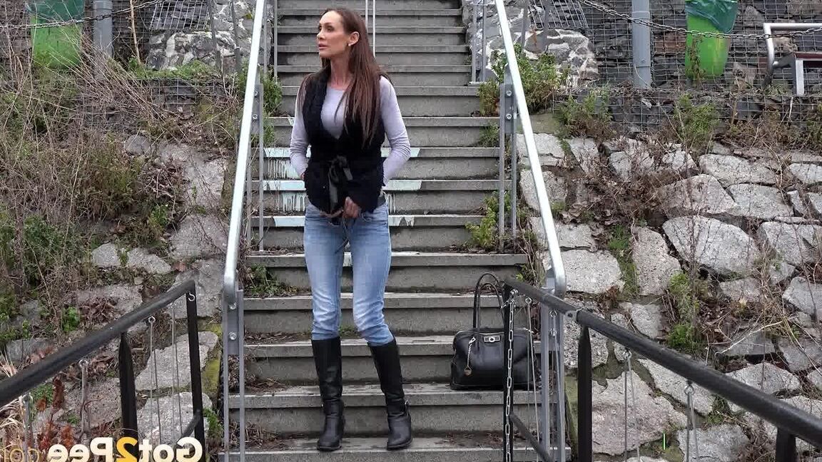 15P Sexy brunette babe pisses in public on some steps