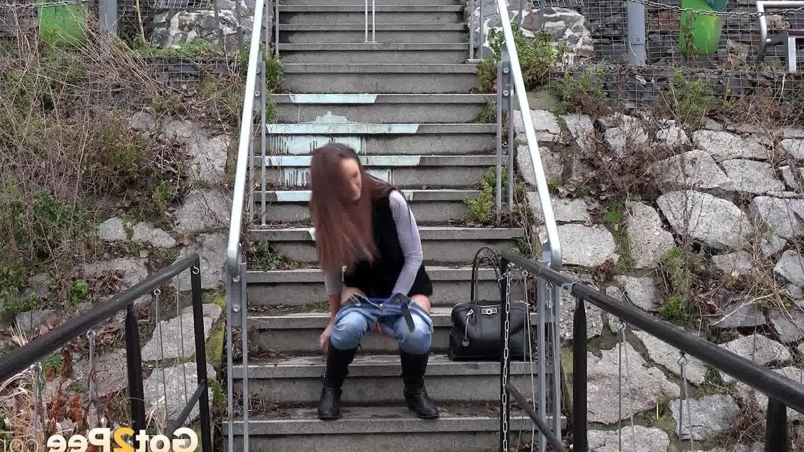 15P Sexy brunette babe pisses in public on some steps