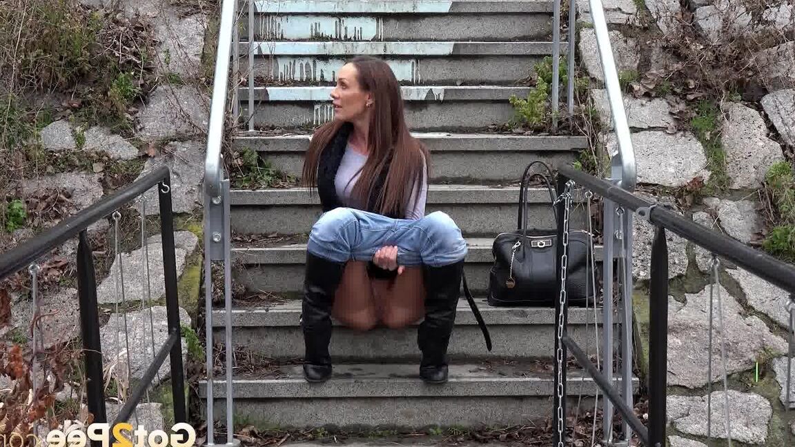 15P Sexy brunette babe pisses in public on some steps
