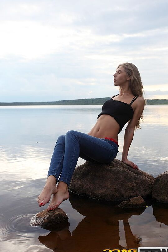 16P Girl next door Megan pulls out her tits while sitting on a rock in the lake