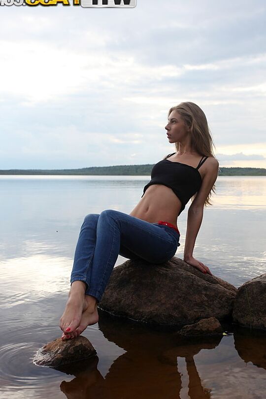 16P Girl next door Megan pulls out her tits while sitting on a rock in the lake