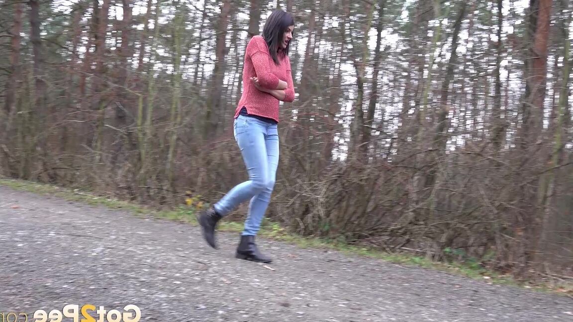 15P Tiny Tina squats on a wooden bench alongside a path for an urgent piss