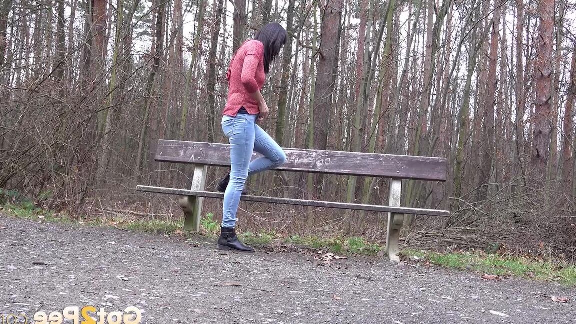 15P Tiny Tina squats on a wooden bench alongside a path for an urgent piss