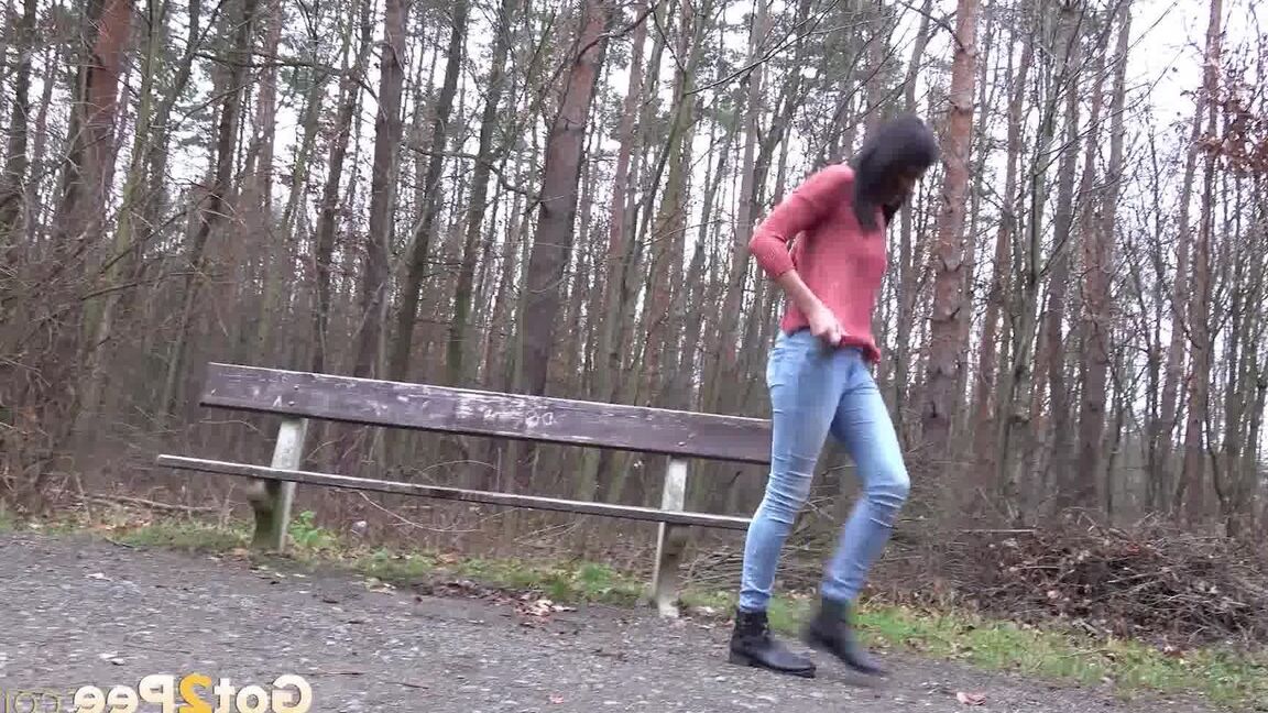 15P Tiny Tina squats on a wooden bench alongside a path for an urgent piss