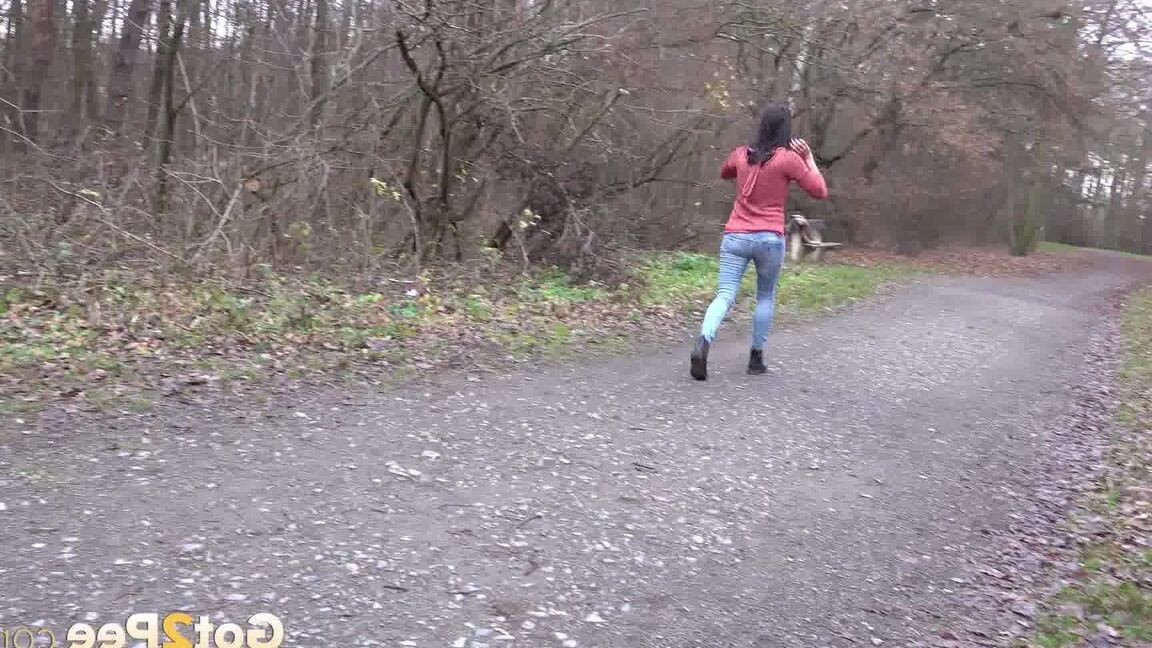 15P Tiny Tina squats on a wooden bench alongside a path for an urgent piss